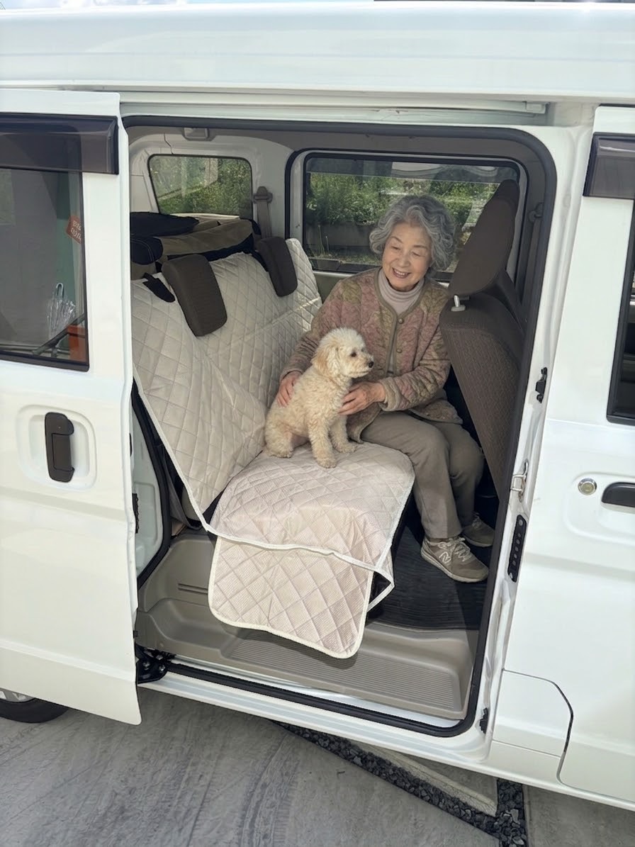 シートカバーを備えた後部座席で飼い主様とペットが同乗する様子